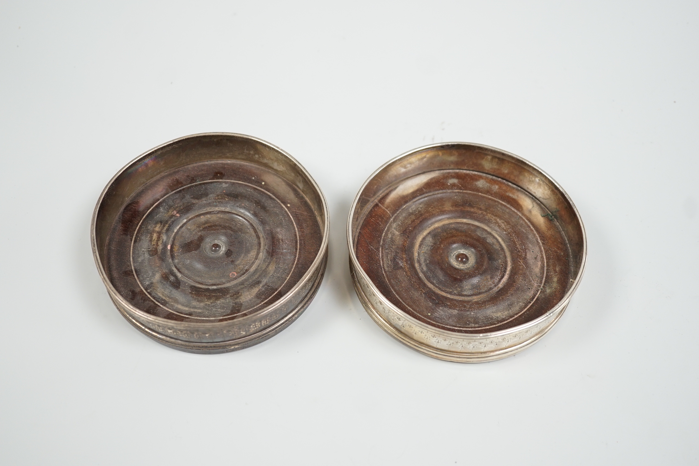 A pair of George III silver mounted wine coasters, makers mark rubbed, London, 1786, diameter 11.4cm.